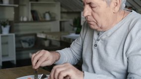 Happy senior man eating a scramble on a white plate with vegetables. Elderly male using knife and fork to cutting meal, has a breakfast. Balanced diet, cooking, culinary. Food concept. Old person
 - Powered by Shutterstock - Get 15% off with code: PIKWIZARD15