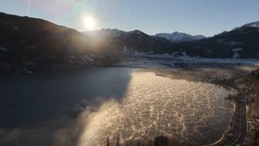 sunrise over frozen lake cracked ice shimmering with golden light, aerial drone survey capturing intricate ice patterns, mountain - Powered by Shutterstock - Get 15% off with code: PIKWIZARD15