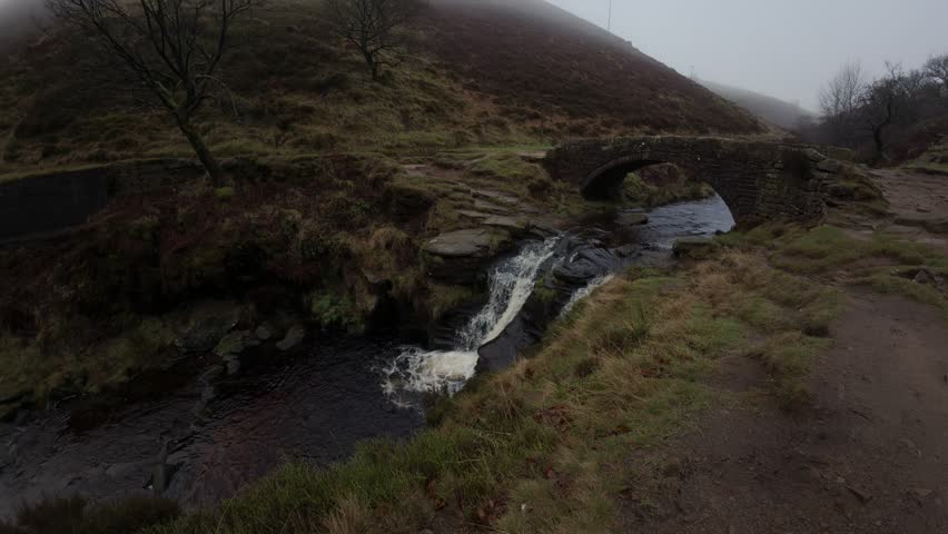 A cold winter misty morning in a remote valley with waterfalls and ponds. 3 Shires heads. UK