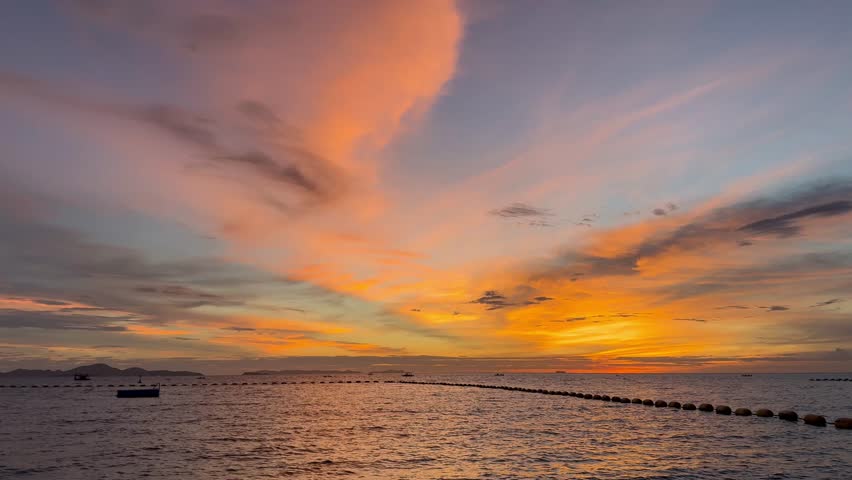 The dusk sky as the sun sets over the horizon at Pattaya Beach, Thailand.