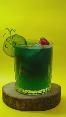 Fresh Green Cocktail with Lime and Herbs on Yellow Background, Healthy Summer Drink