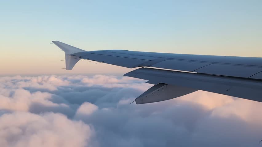 View from airplane window above white clouds. 
