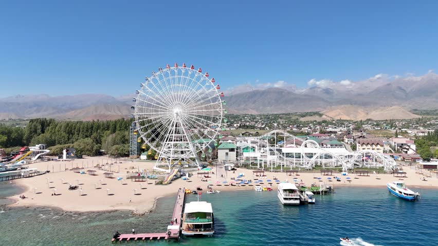 Cholpon-Ata, Kyrgyzstan – October 4, 2025: Ferris wheel by Issyk-Kul Lake with scenic mountains in the background, a popular tourist spot.