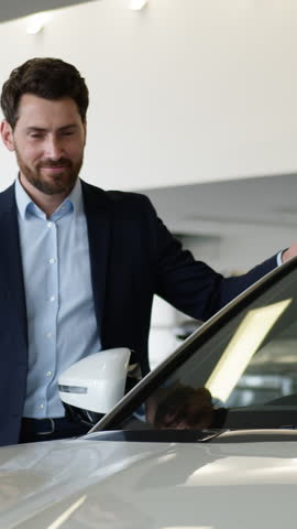 Excited dreaming Caucasian business man choosing new car inside auto showroom happy buyer touching dream vehicle satisfied client purchase male businessman customer buying decision rental service shop