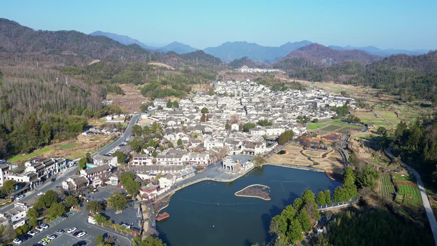 Xidi, China: Aerial drone footage of the famous Xidi ancient village with its traditional Hui architecture its lakeside memorial archway, near Huangshan in Anhui province in China. 