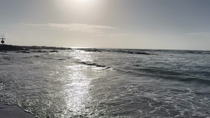Sun kissed shoreline at Bloubergstrand beach near Cape Town, South Africa.