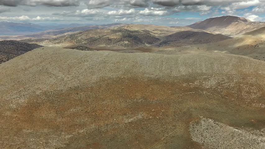 Aerial view of Atlas Mountains landscape stretching across semi arid ranges in North Africa region. Overhead mountain ridges show dry plateaus and vast wilderness from Moroccan to Algerian highlands.