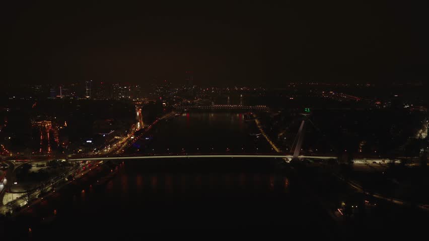Aerial night view of Bratislava skyline with the Danube River and illuminated bridges. Winter city atmosphere, urban lights, calm evening scene in the Slovak capital.