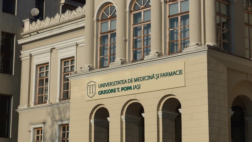 Exterior view of Grigore T. Popa University of Medicine and Pharmacy in Iasi, classical architecture with columns, arched entrance, signboard, and sunny weather