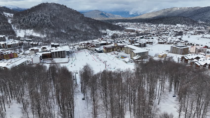 Aerial view of Bakuriani winter resort town with hotels and snow-covered mountains, Georgia