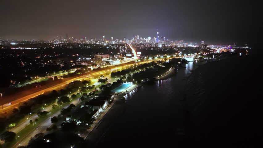 Night aerial view of Lake Ontario, Lake Shore Boulevard, and the Toronto skyline.