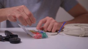 Closeup hands assembling ethernet connector on white table using pliers to strip and crimp cable coil visible calm studio lighting network installation demonstration - Powered by Shutterstock - Get 15% off with code: PIKWIZARD15
