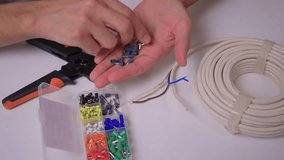 Closeup hands assembling ethernet connector on white table using pliers to strip and crimp cable coil visible calm studio lighting network installation demonstration - Powered by Shutterstock - Get 15% off with code: PIKWIZARD15