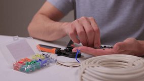 Closeup hands assembling ethernet connector on white table using pliers to strip and crimp cable coil visible calm studio lighting network installation demonstration - Powered by Shutterstock - Get 15% off with code: PIKWIZARD15