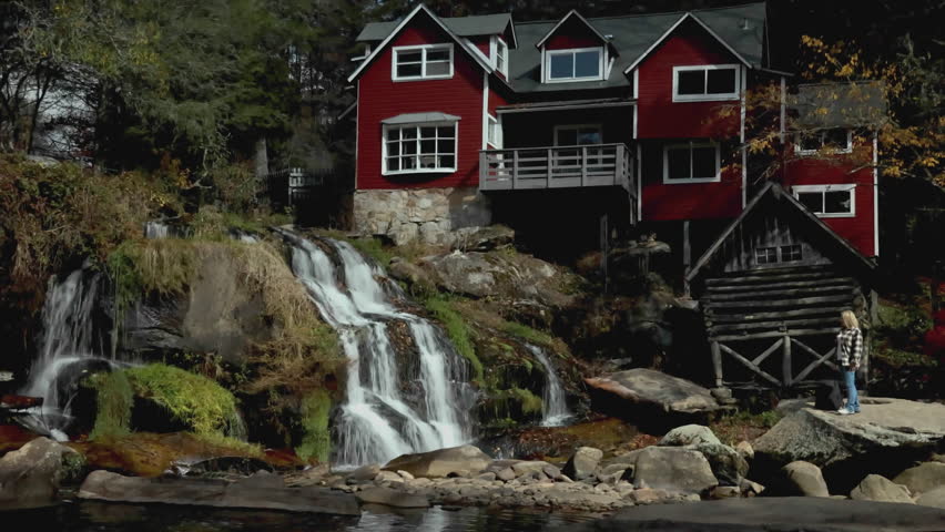 Waterfalls at Mill Shoals Woman Standing Next to Red House admire the falls and autumn colors