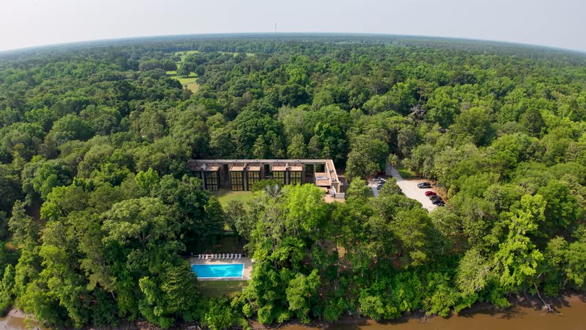 Drone footage shows Middleton Place Plantation estate near Charleston, South Carolina, captured from above. The aerial view highlights the historic brick buildings, swimming pool, lush surrounding for