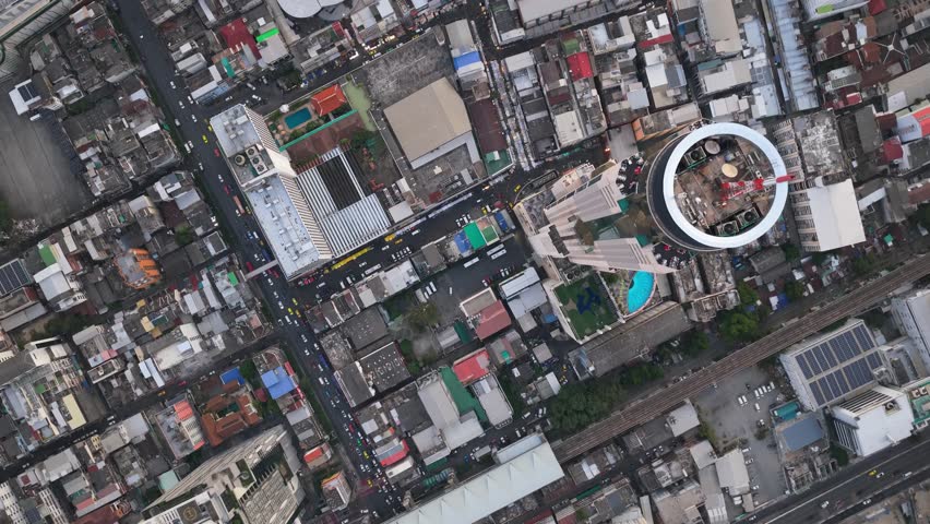 Top down aerial view over the Baiyoke Tower II, revealing surrounding urban landscape and busy streets of Bangkok