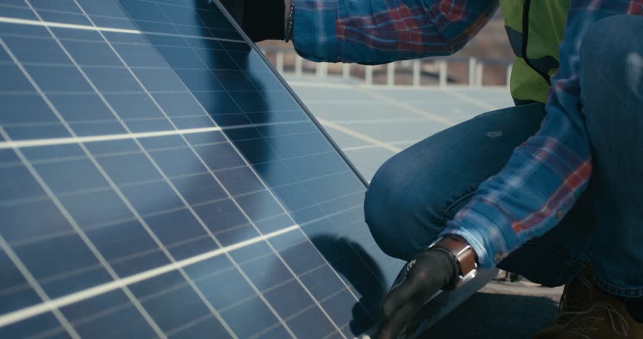 Technician lowering a solar panel into position, demonstrating renewable energy installation, clean power technology, and sustainable electricity systems.
