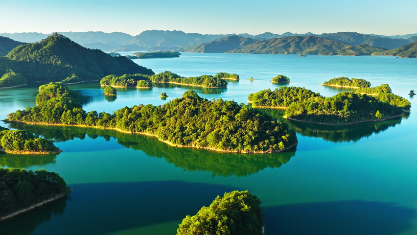 Aerial shot of beautiful blue lake with green islands and mountain natural landscape in the morning. Famous Qiandao Lake scenery in Hangzhou, China. 