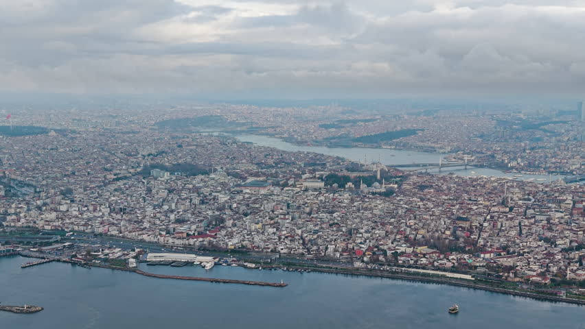 Vast aerial shot of Istanbul’s Sultanahmet district showing dense historic buildings, mosques, and urban texture with the modern skyline in the distance. Cultural heritage and city life. UHD. Turkey