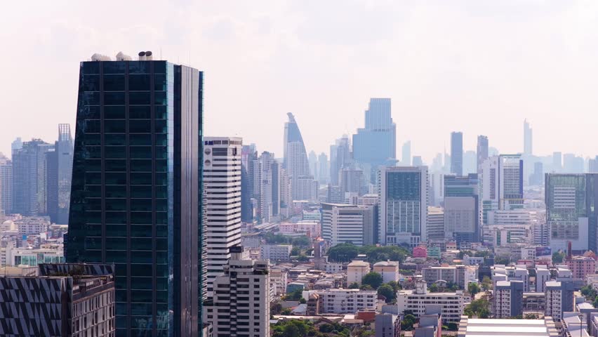 Aerial view of Bangkok metropolitan skyline in Thailand. Hazy cityscape with modern high rise buildings including Q House Lumpini and contemporary architecture