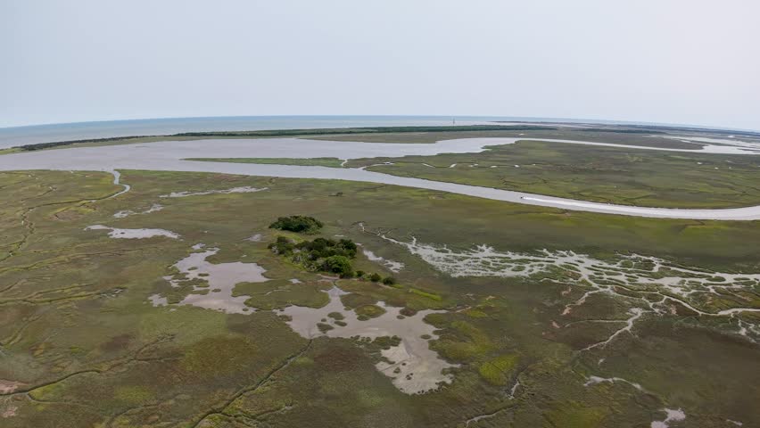 Aerial drone footage of a vast marshland at Middleton Place Plantation near Charleston, South Carolina, with patches of open water and grassy vegetation spread across the landscape.