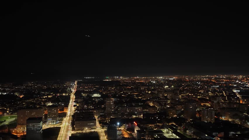 Plane flying over the city of porto at night