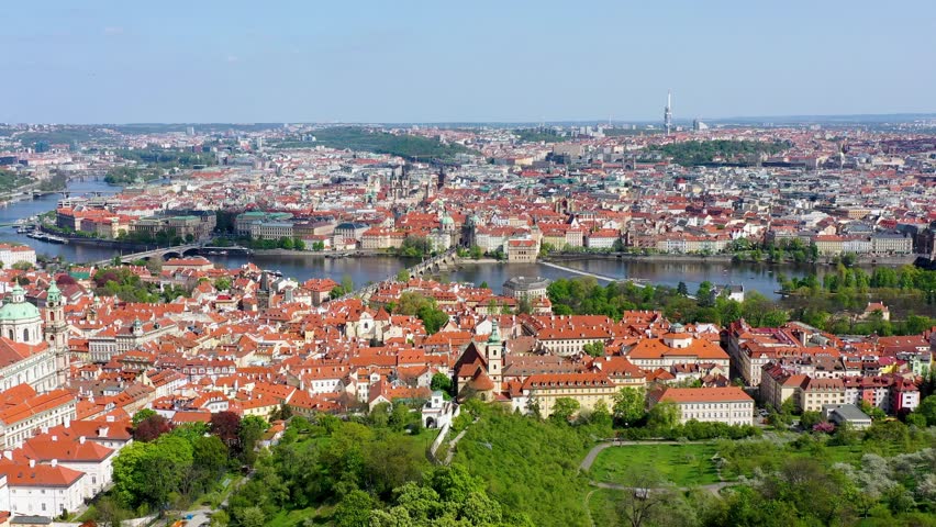 View of Prague featuring vibrant rooftops on a sunny day in summer. Aerial view of Prague, Charles Bridge over Vltava river in Prague, Czechia. Old Town of Prague, Czech Republic.