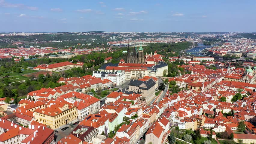 View of Prague featuring historic castle and vibrant rooftops on a sunny day in summer. Aerial view of Prague, Charles Bridge over Vltava river in Prague, Czechia. Old Town of Prague, Czech Republic.