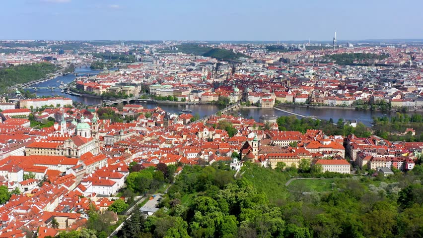 View of Prague featuring vibrant rooftops on a sunny day in summer. Aerial view of Prague, Charles Bridge over Vltava river in Prague, Czechia. Old Town of Prague, Czech Republic.