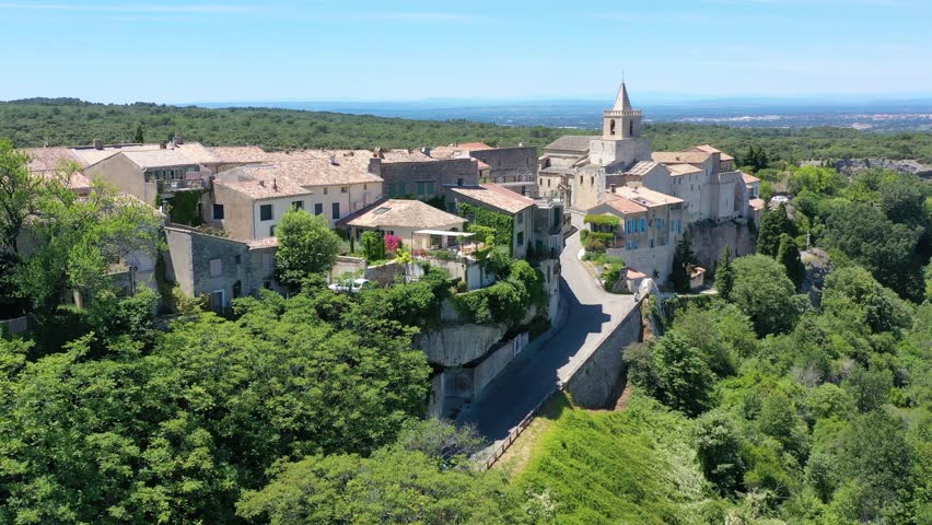 View of Venasque village with old church Notre Dame de Vie to landscape of Luberons, Provence, France. Beautiful Church and houses in the town of Venasque, Provence, France.