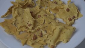 Traditional Indonesian peanut crackers on a white plate. Crispy savory snack with peanuts and lime leaves. Authentic Asian snack photography for culinary and small business concepts. 4K high quality. - Powered by Shutterstock - Get 15% off with code: PIKWIZARD15