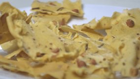 a traditional Indonesian crispy deep-fried cracker topped with peanuts and lime leaves. High-quality 4K rotating shot of savory ethnic snack with crunchy texture on white plate. Perfect for Asian culinary, street food, and authentic snack content. - Powered by Shutterstock - Get 15% off with code: PIKWIZARD15