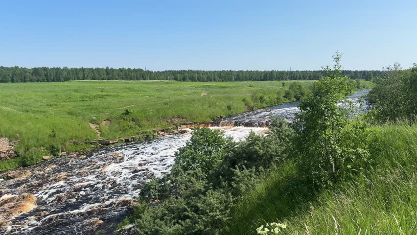 A wide, rushing waterfall with small cascade, creating foam, capturing the raw power of nature.