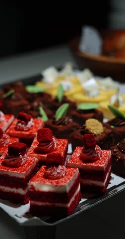 Red velvet mini cakes elegantly arranged on a luxury dessert buffet, perfect for celebration and gourmet indulgence. Vertical.