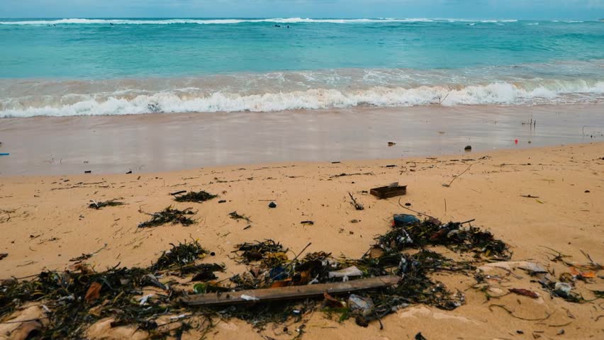 The crashing waves crash against the sand of Sanur Beach, Bali.