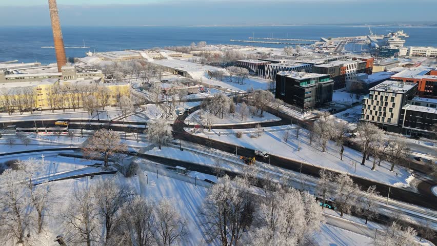 Drone footage of the iconic brutalist Linnahall building in Tallinn during winter. Featuring frozen Baltic Sea ice, snow-covered concrete architecture, and the city harbor shoreline.