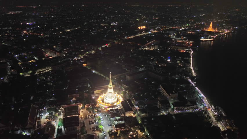 Aerial view on night lights of Wat Arun and Wat Prayurawongsawas Warawihan, Bangkok, Thailand, 4k
