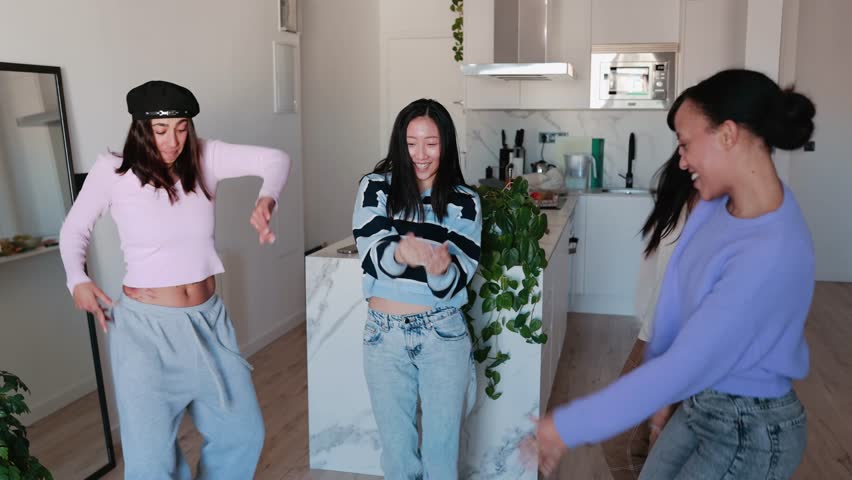 Group of four female friends laughing and dancing while singing