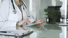 Doctor woman accessing patient data on digital tablet, managing healthcare records in modern medical office. Medicine, health care and science concept - Powered by Shutterstock - Get 15% off with code: PIKWIZARD15