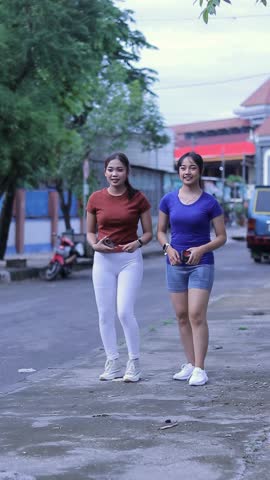 Two young women in athletic wear are captured in various stages of jogging along a street, showcasing their commitment to a healthy and active