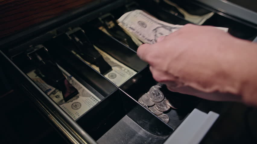 Cash register drawer opened during payment process, cashier hand placing banknotes inside and preparing change, close up of checkout operation in retail or cafe environment. High quality 4k footage