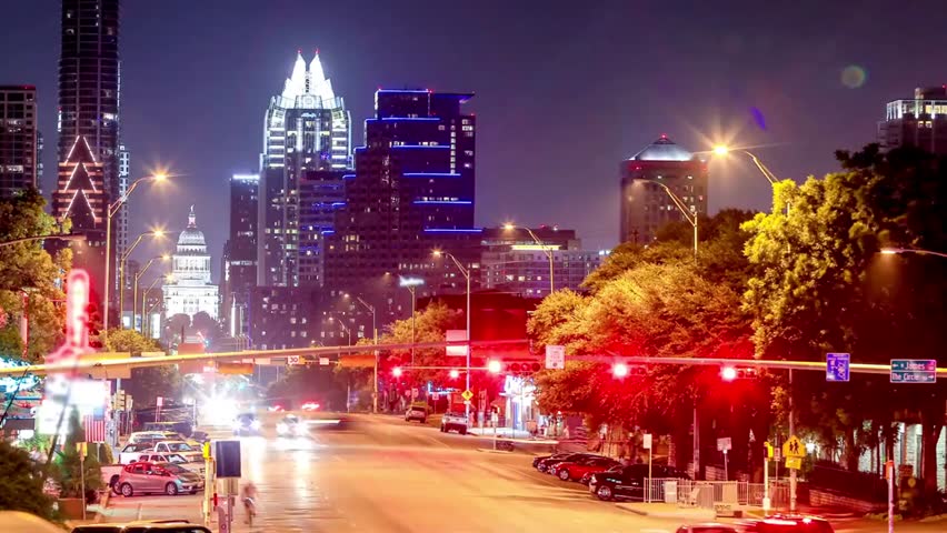 Night view of Austin, Texas cityscape with illuminated skyscrapers and busy street traffic, capturing vibrant urban energy and the modern metropolitan skyline.