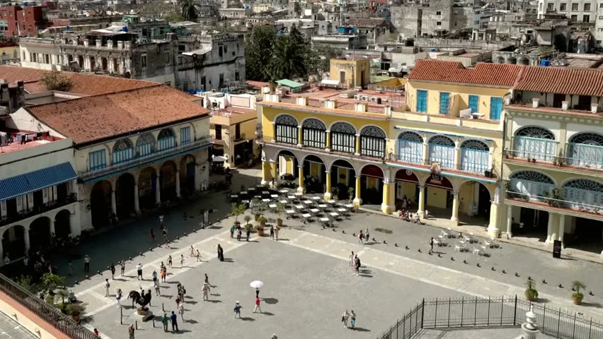 People gather in Havana’s historic Plaza Vieja, enjoying the vibrant square, colorful architecture, and lively cultural atmosphere of Cuba.