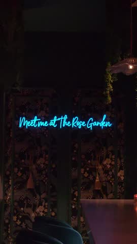 Interior of a moody botanical bar filled with plants, atmospheric lighting, and decorative details.