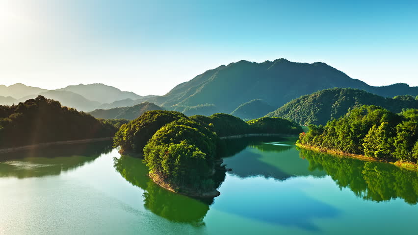 Aerial shot of beautiful blue lake with green islands and mountain natural landscape in the morning. Famous Qiandao Lake scenery in Hangzhou, China. 