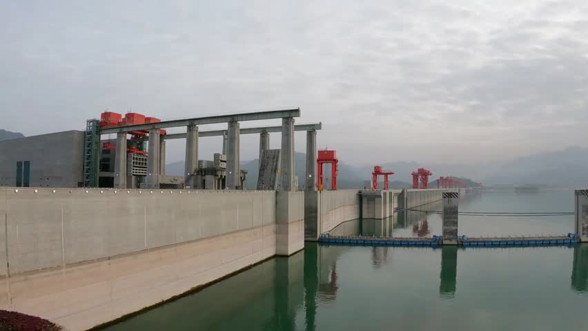 The Three Gorges Dam stretches across the Yangtze River in China on a cloudy day, ideal for engineering, infrastructure, and travel projects.