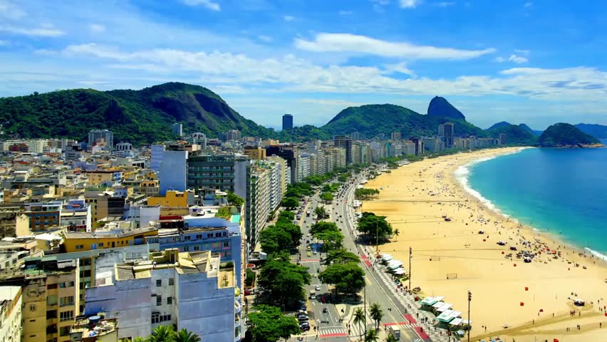 Rio de Janeiro cityscape with Copacabana Beach on a sunny day, showcasing urban skyline, golden sands, vibrant beach life, and coastal scenery.