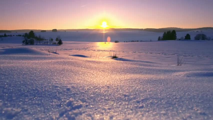 Beautiful winter landscape with snow-covered fields and a bright sunrise or sunset, capturing serene nature, soft light, and seasonal scenery.