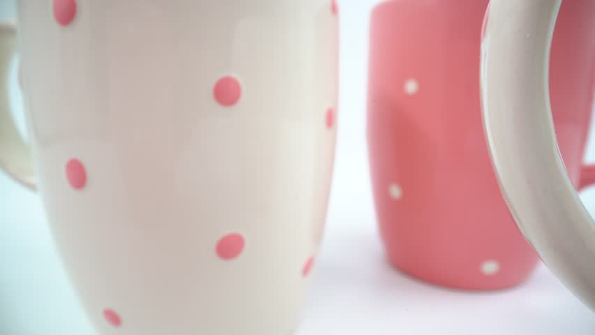 Close up of pink and white ceramic mugs